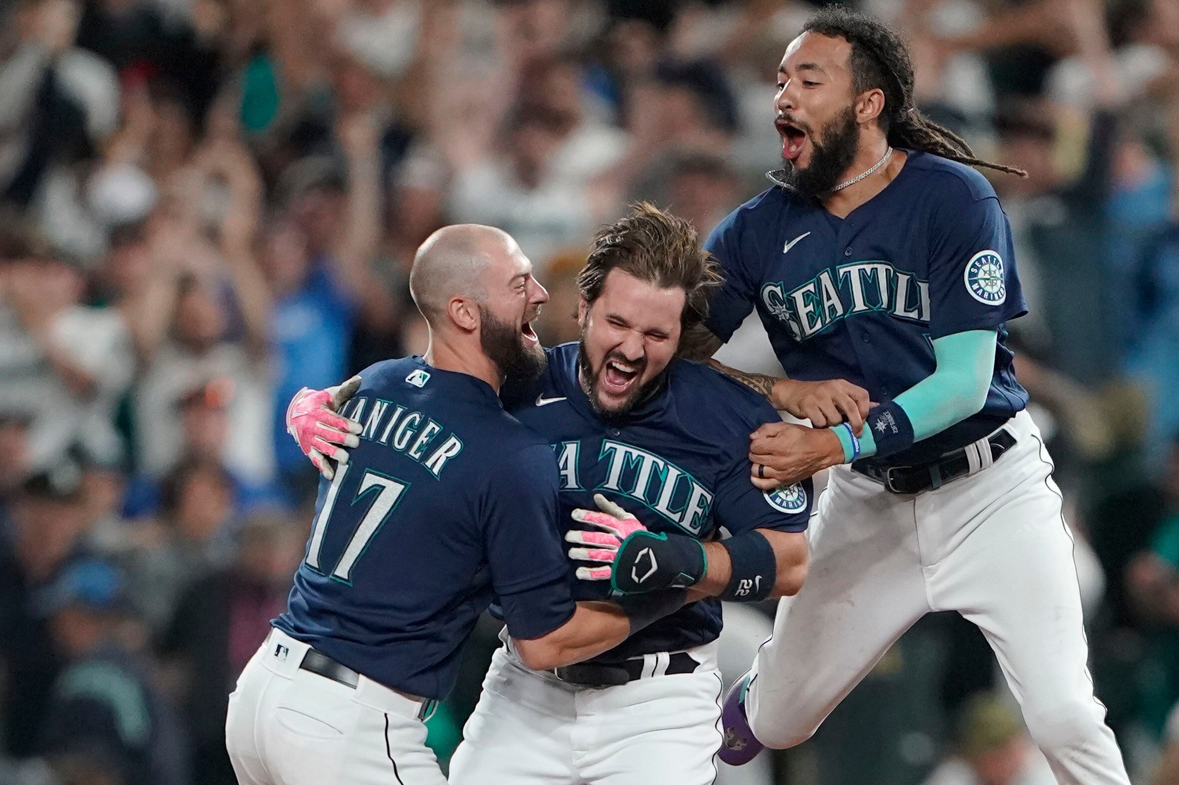 Seattle Mariners' Eugenio Suarez holds up a heart after hitting a